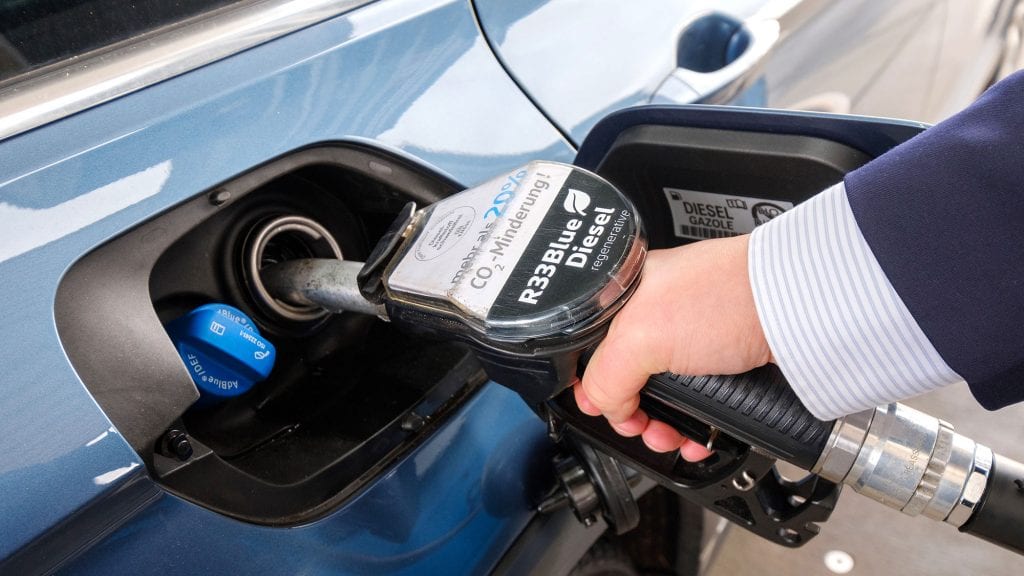 Model Hand filling up a new low-emissions vehicle with dubbed "Blue Gasoline"