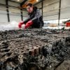 A technician checks the possible remaining voltage of a completely burned Lithium-ion car battery before its dismantling by the German recycling firm Accurec in Krefeld