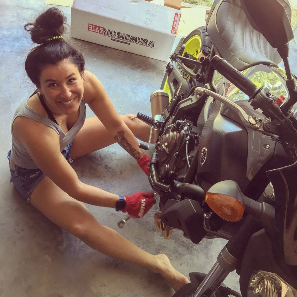 Patricia Fernandez working on a motorcycle