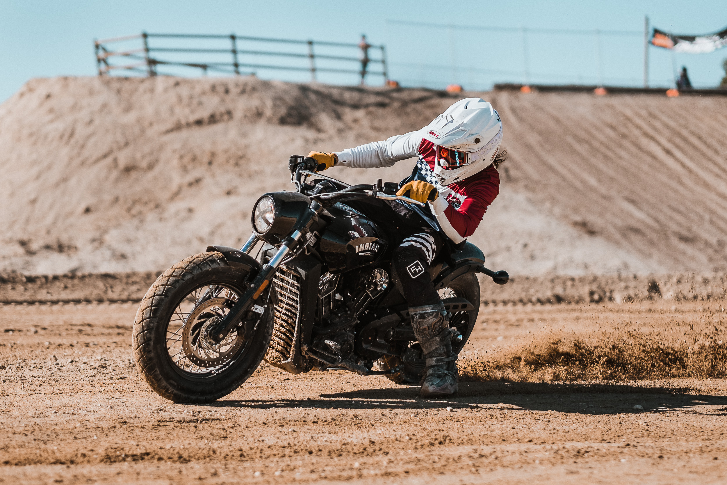  A motorcycle rider on an Indian Scout races on a dirt flat track circuit