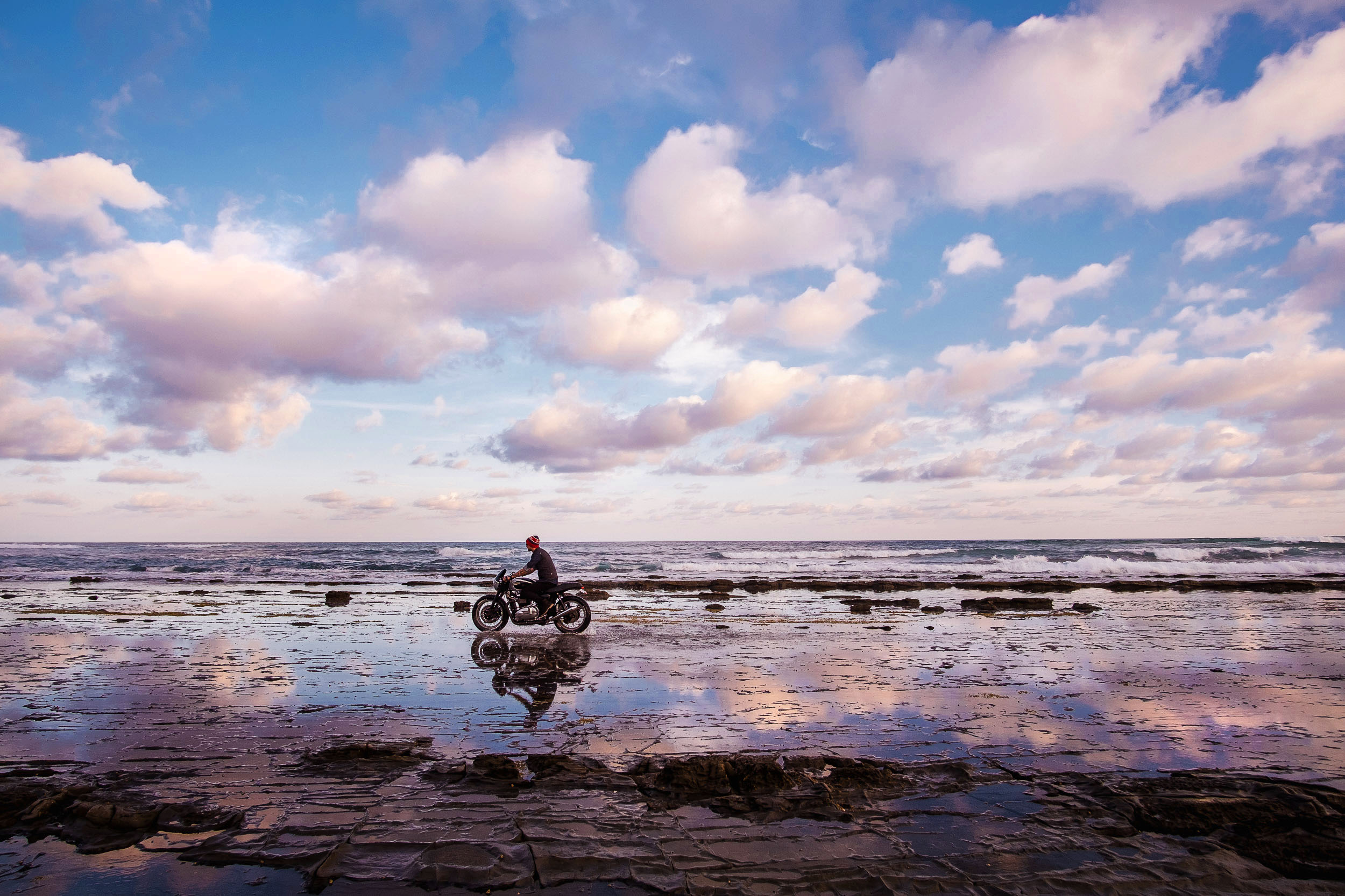 A motorcycle rider on an Aussie beach at dusk