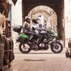 Rider and pillion on the Kawasaki Versys 1000 riding through a narrow street