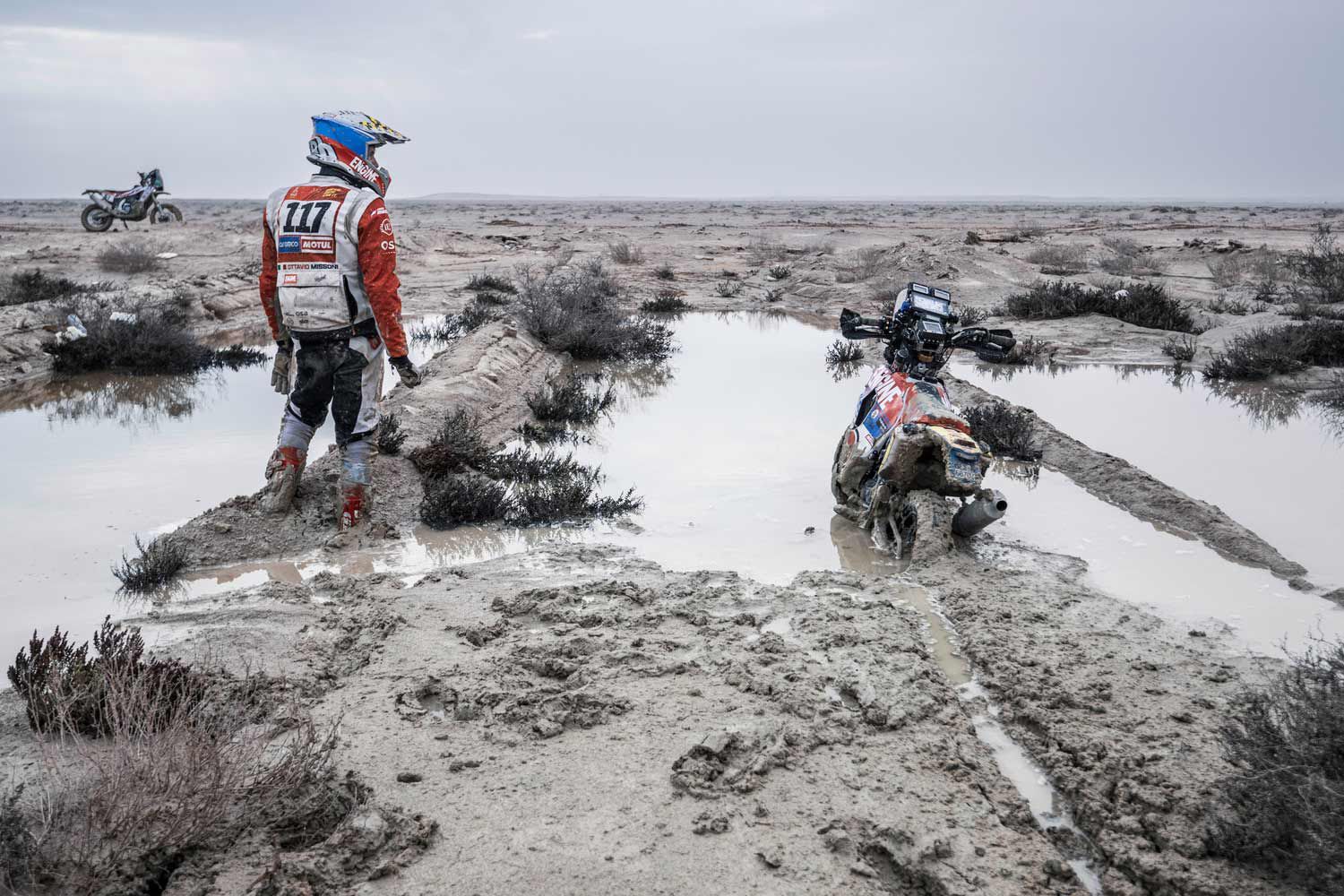 Ottavio Missoni, privateer, takes stock of his mud-bound Honda during the final Stage 14. But he finished. Dream accomplished.