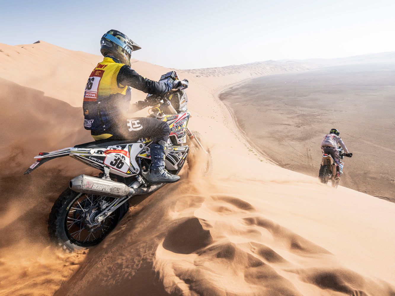 Better to lead or follow? Jerome Martiny’s Team Dumontier Racing Husqvarna, left, heads into the Empty Quarter during Stage 11.