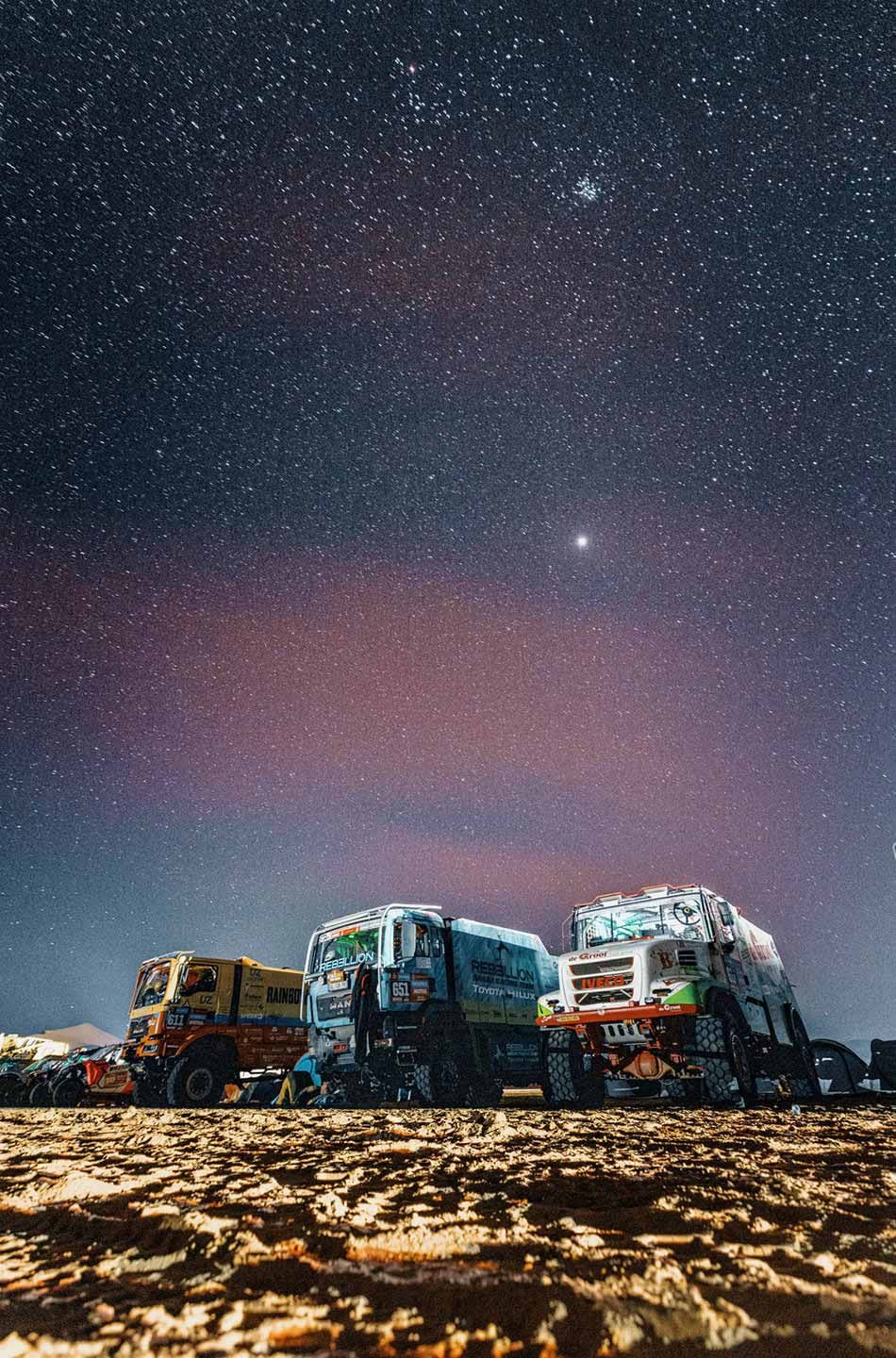 Long-exposure shot at night of trucks by the bivouac during Stage 6.